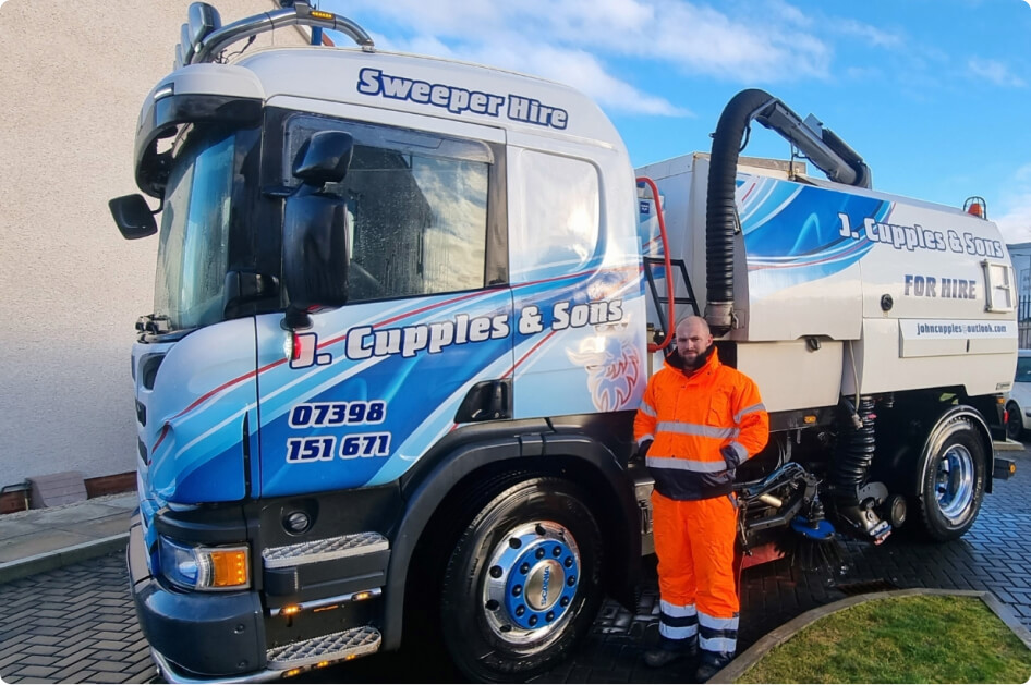 John from J Cupples & Sons standing in front of Road Sweeper